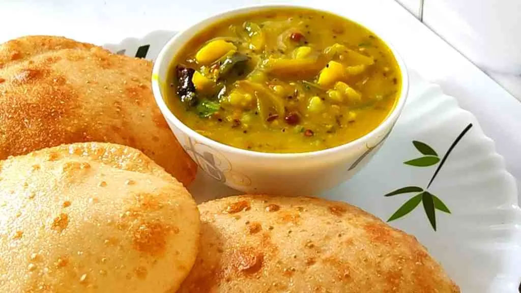 Puri Bhaji — Two golden, puffed puris served with flavorful spiced bhaji, prepared fresh and full of authentic Indian taste